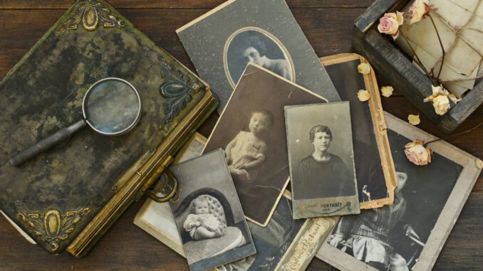 Still-life with old photo album and historical photos of family